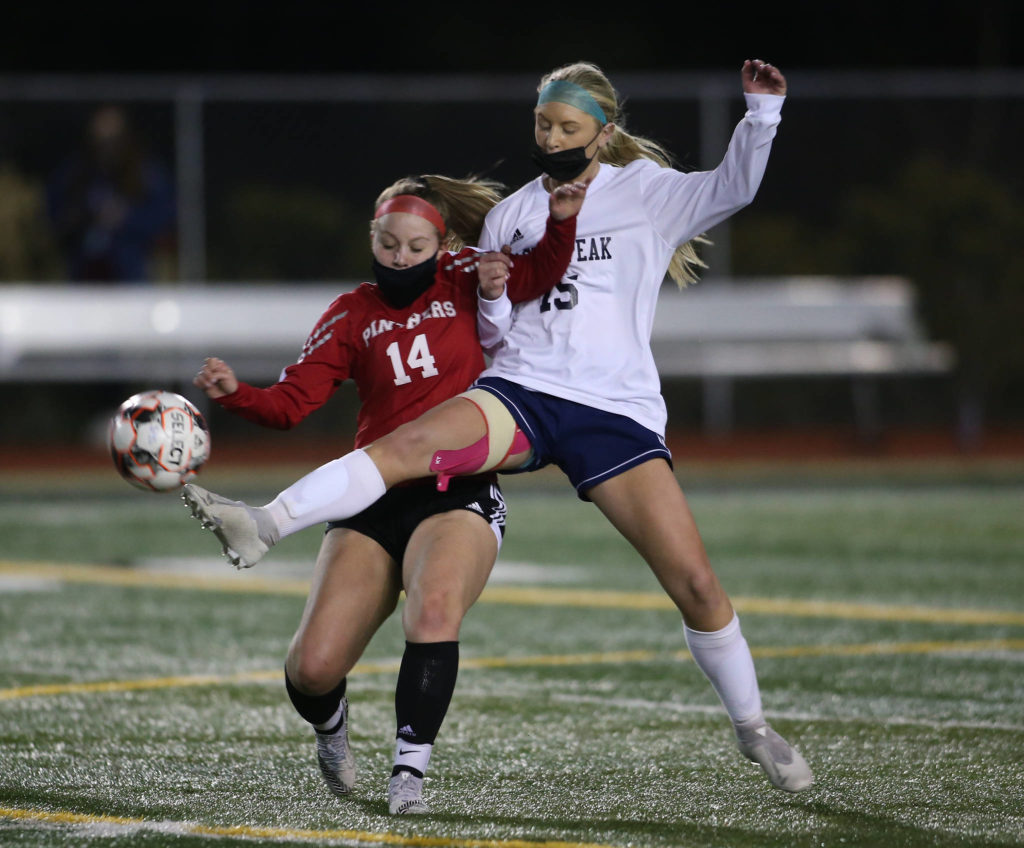 Glacier Peak’s Alex Prescott kicks the ball away from Snohomish’s Erin Anderson during a girls soccer match at Veterans Memorial Stadium on Monday in Snohomish. (Andy Bronson / The Herald)
