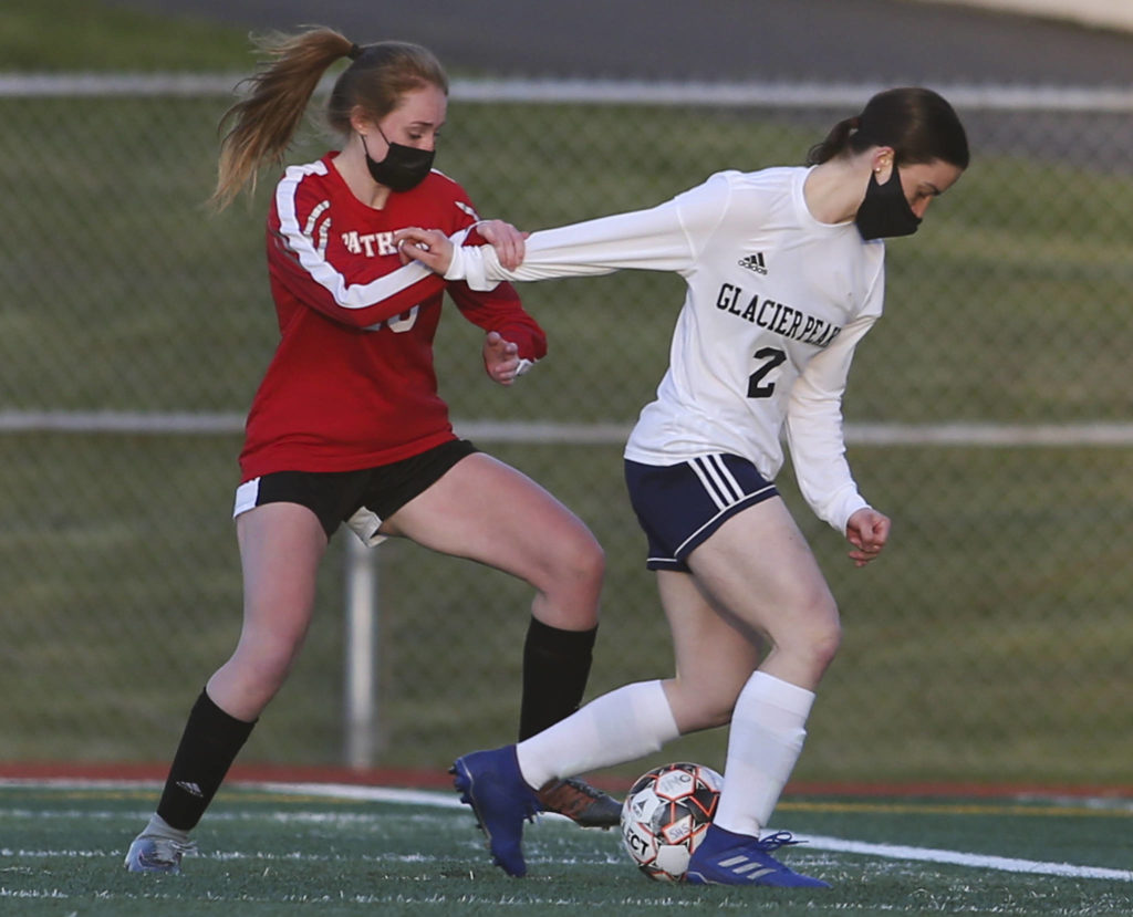 Snohomish’s Emma English tries to hold back Glacier Peak’s Greta Henrie during a girls soccer match at Veterans Memorial Stadium on Monday in Snohomish. (Andy Bronson / The Herald)
