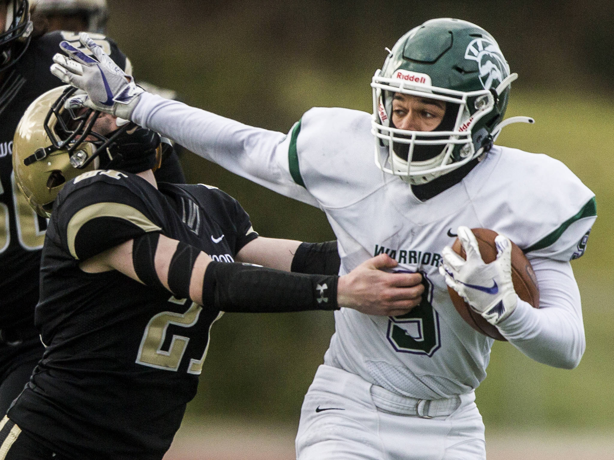 Edmonds-Woodway’s Steele Swinton (right) stiff-arms a Lynnwood defender during a game on March 26, 2021, in Edmonds. (Olivia Vanni / The Herald)