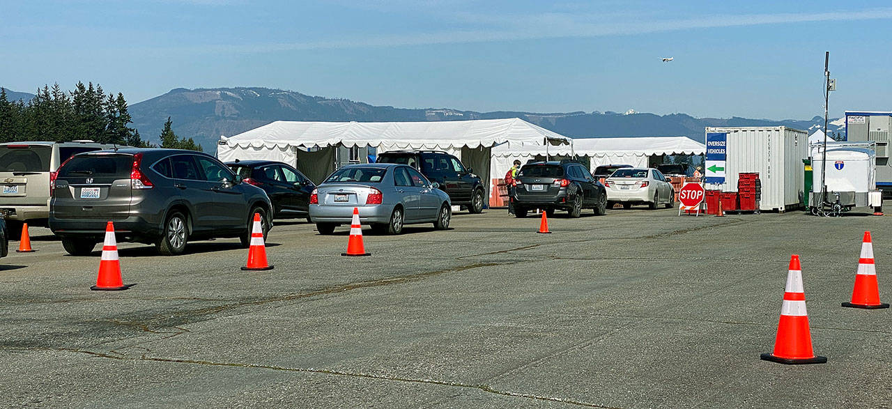 Vehicles line up Wednesday at Arlington Municipal Airport, one of Snohomish County’s public vaccination sites. (Sue Misao / The Herald)