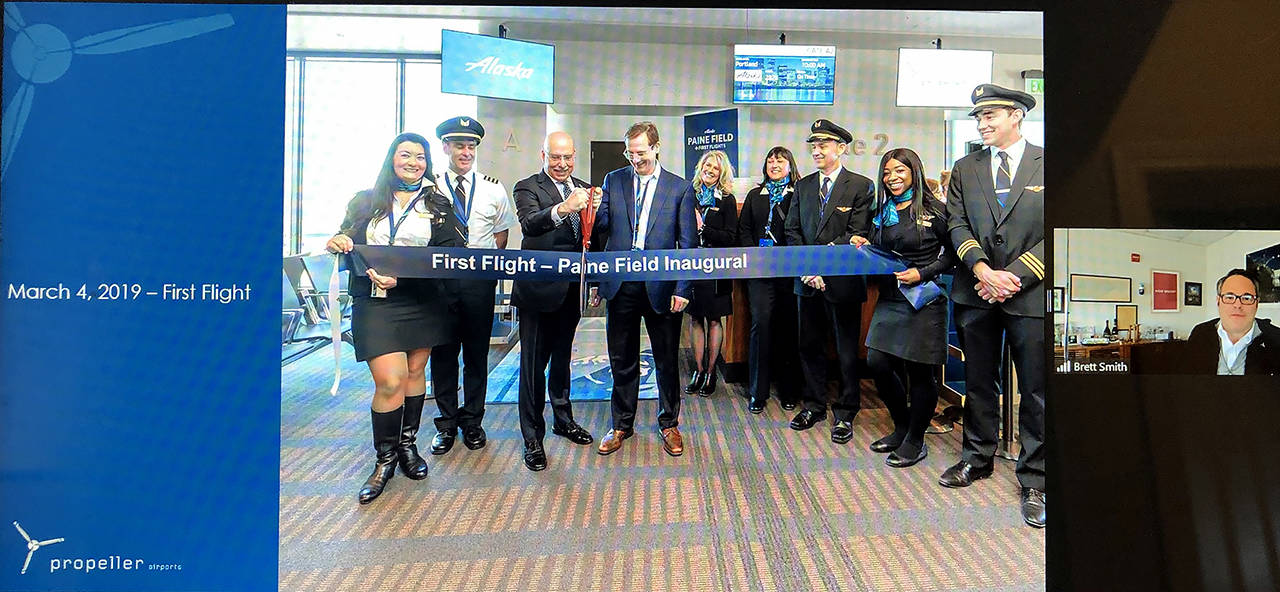 Brett Smith (right), CEO of Propeller Airports, shares a scene from the March 4, 2019 opening of the commercial airline terminal at Paine Field during a Lynnwood Chamber of Commerce virtual gathering on March 17, 2021.