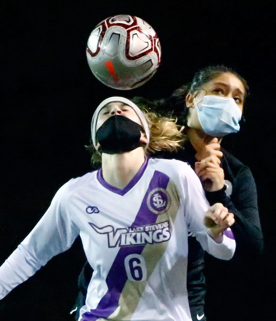 Lake Stevens’ Delaine Polly heads the ball with Jackson’s Maki Quiyono behind her during a March 18 game at Everett Memorial Stadium. (Kevin Clark / The Herald)
