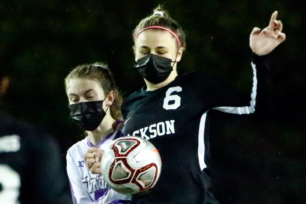Jackson’s Abigail McKay controls the ball with Lake Stevens’ Delaine Polly trailing during a March 18 contest at Everett Memorial Stadium. (Kevin Clark / The Herald)

