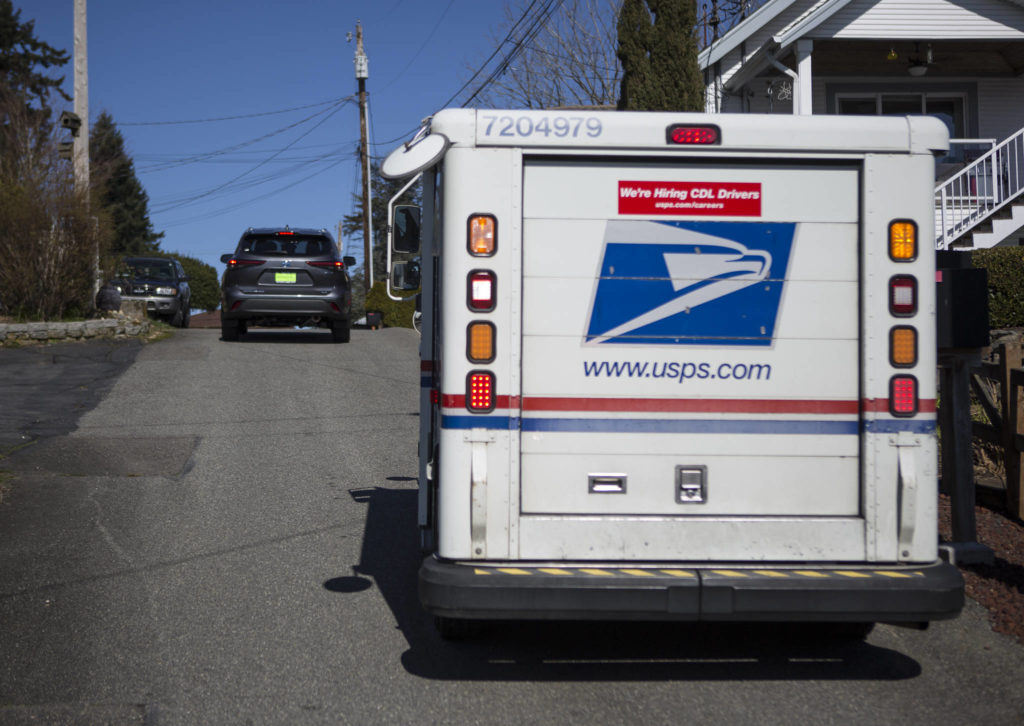 Two cars navigate narrow West Ibberson Drive on March 10 in Everett. The city had proposed to put a pedestrian trail along the road but removed the segment after neighbors criticized the route. (Olivia Vanni / The Herald)
