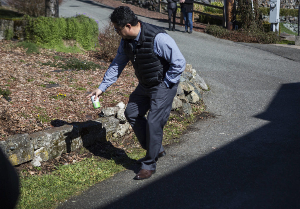 A neighbor talks March 10 about having to rebuild a rock wall consistently because of vehicles not being able to make the turn on West Ibberson Drive in Everett. The City of Everett scrapped designs to put a pedestrian trail on the road after neighbors opposed it. (Olivia Vanni / The Herald)
