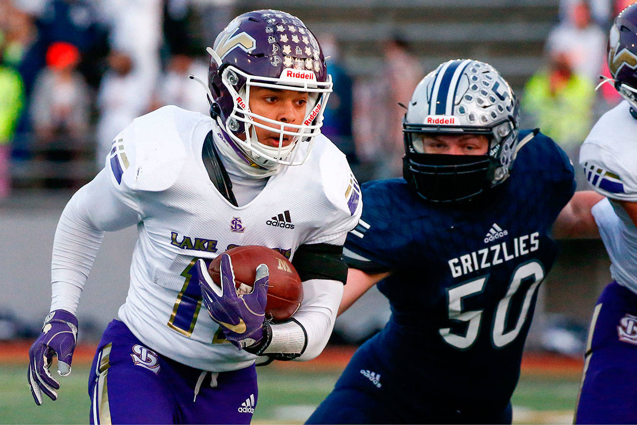 Lake Stevens' Jayden Limar rushes with Glacier Peak's Hunter Morrison Thursday night at Veterans Memorial Stadium in Snohomish on April 1, 2021. (Kevin Clark / The Herald)