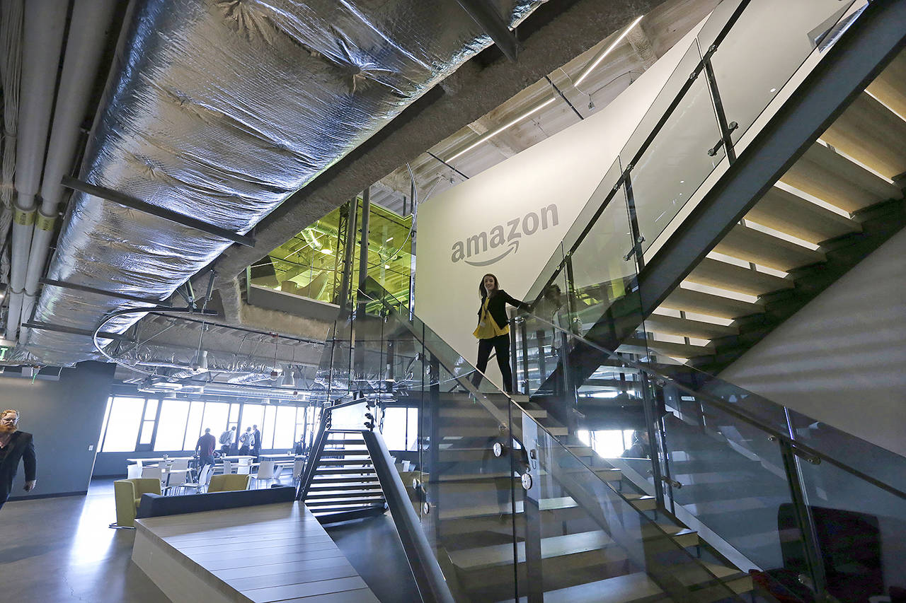 In this 2017 photo, an Amazon worker walks down steps in a company office in Seattle (AP Photo/Elaine Thompson, File)