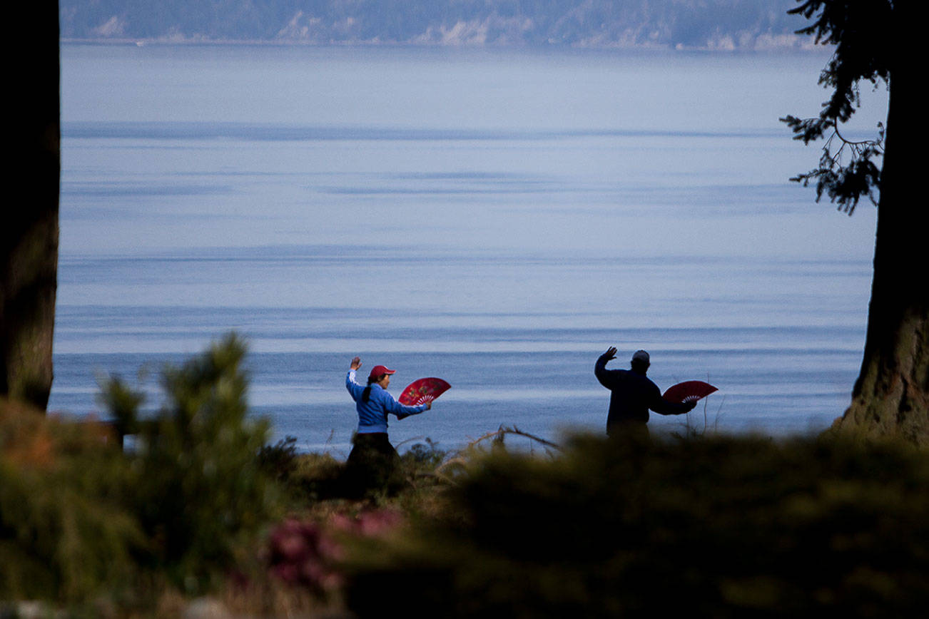 Dongyue Zhuang and Hong Li do tai chi fan at Harborview Park on Tuesday, April 6, 2021 in Everett, Wa. (Olivia Vanni / The Herald)