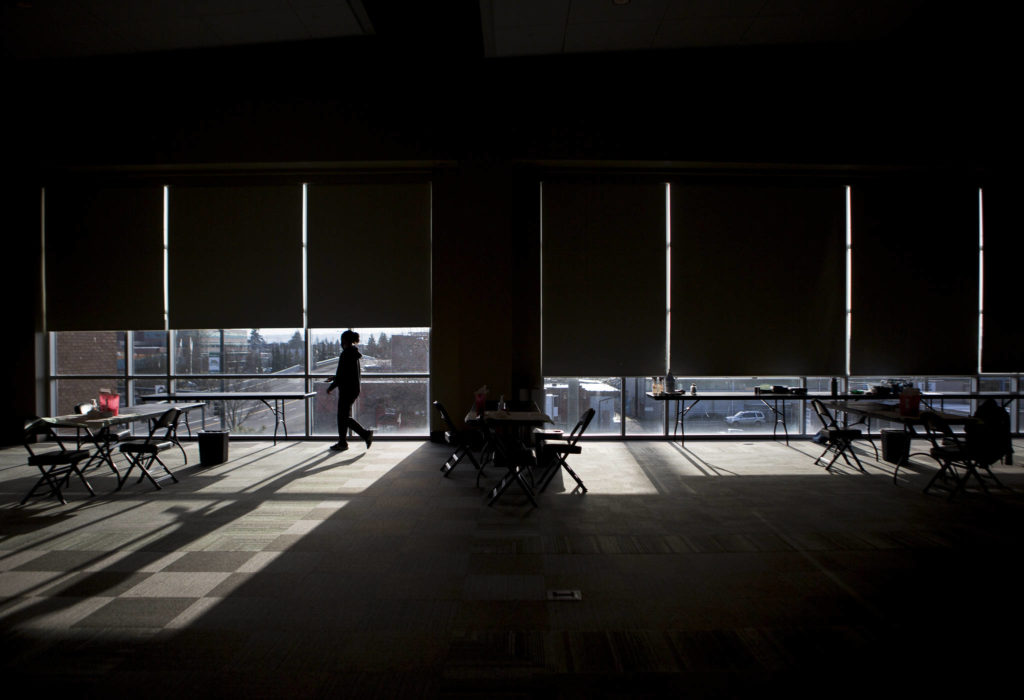 Workers set up the vaccination stations at Angel of the Winds Arena on Tuesday in Everett. (Olivia Vanni / The Herald)
