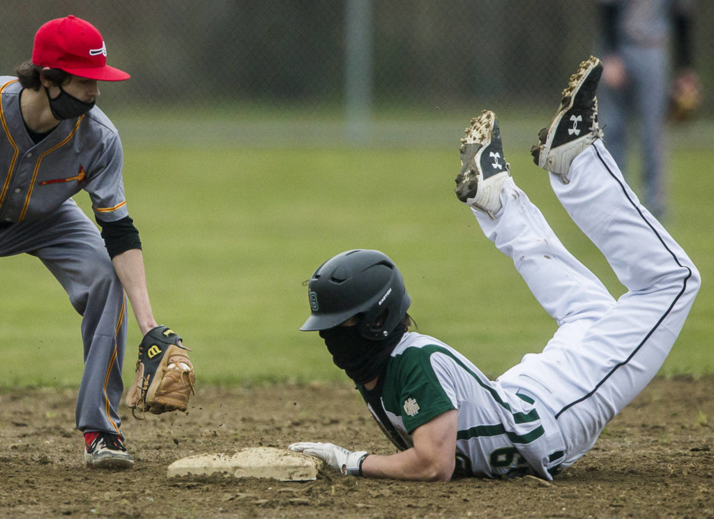 Marysville Getchell’s Bradley Aasen (right) slides into second base as Marysville Pilchuck’s Alex Smith reaches to tag him during a game on April 7, 2021, in Marysville. (Olivia Vanni / The Herald)
