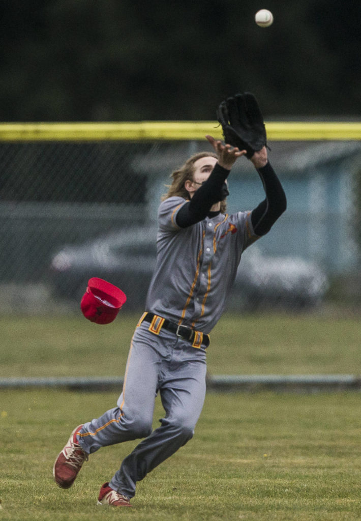 Marysville Pilchuck’s Alex Nybold loses his hat while he runs to catch a ball during a game against Marysville Getchell on April 7, 2021, in Marysville. (Olivia Vanni / The Herald)
