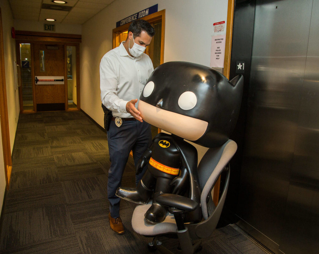 “We are still trying to figure out what to do with him,” said Everett Police Department property crimes Det. Adam Gage, who transports the statue back to a room using a rolling chair. The Batman statue was recovered after it was stolen from an Everett comic book store last year. (Andy Bronson / The Herald)
