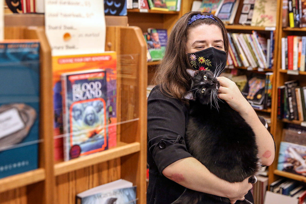 Emily Newman, here with Miranda the cat, bought Main Street Books in Monroe in 2012. (Kevin Clark / The Herald)