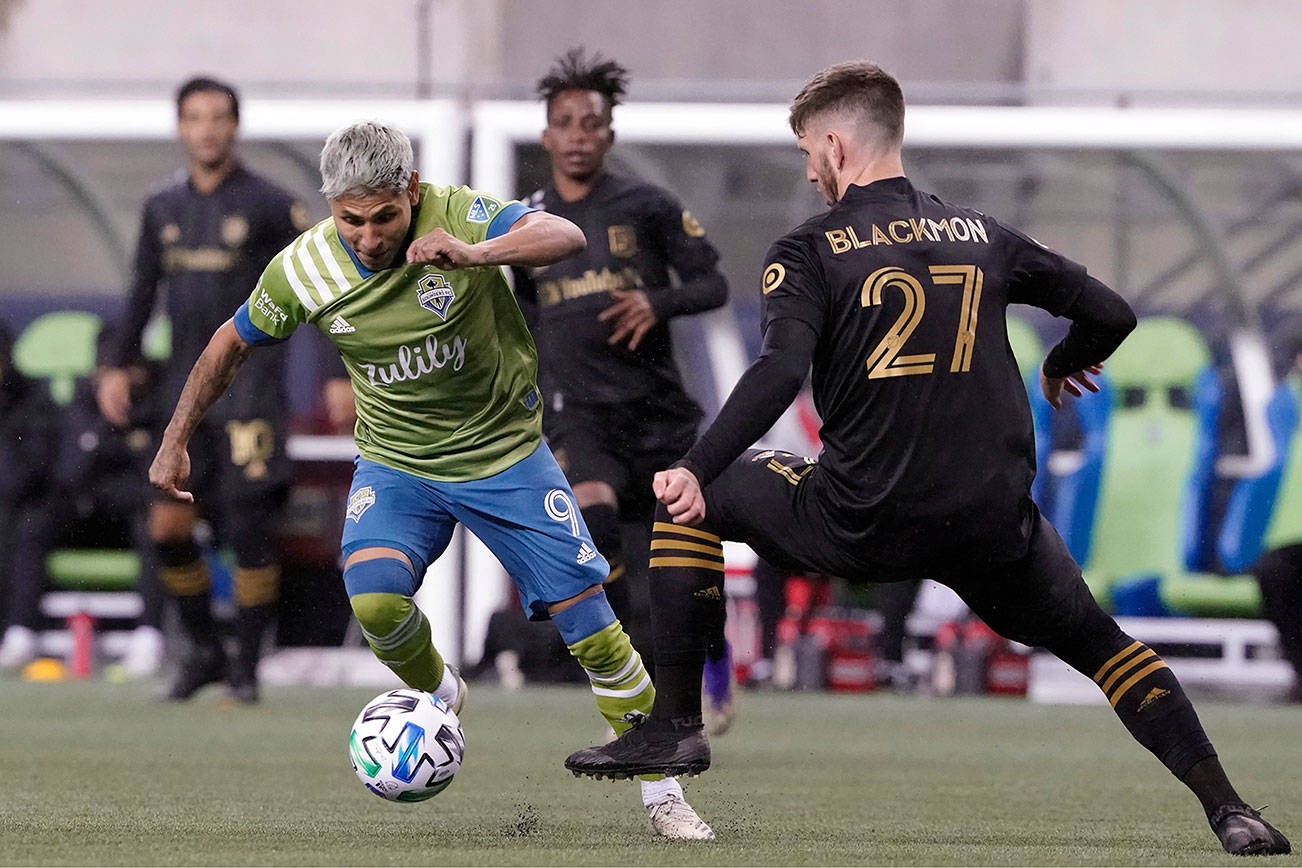 Seattle Sounders forward Raul Ruidiaz (9) dribbles past Los Angeles FC defender Tristan Blackmon during the first half of an MLS playoff soccer match, Tuesday, Nov. 24, 2020, in Seattle. (AP Photo/Ted S. Warren)