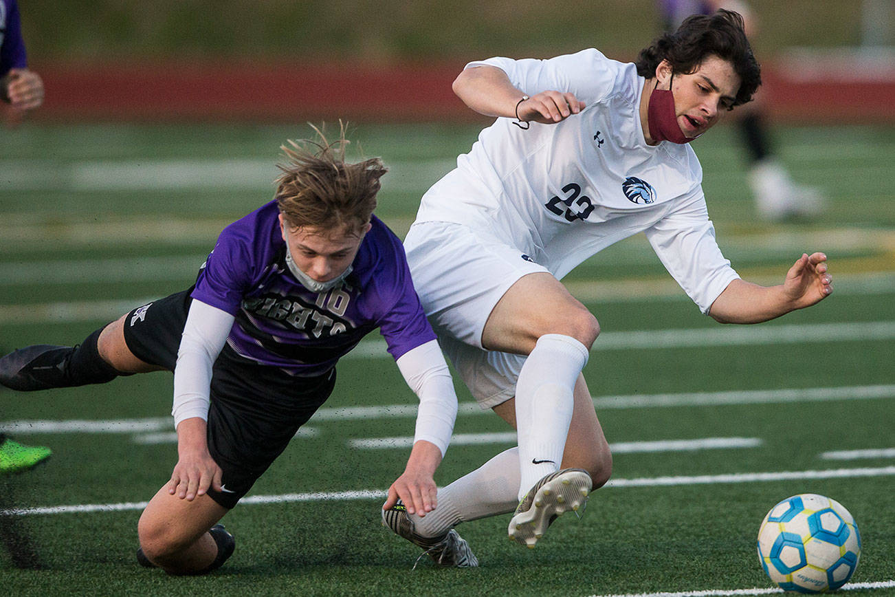 Kamiak's Cade Weatherbie and Meadowdale's River Stewart fall while fighting for the ball during the game on Friday, April 16, 2021 in Mukilteo, Wa. (Olivia Vanni / The Herald)