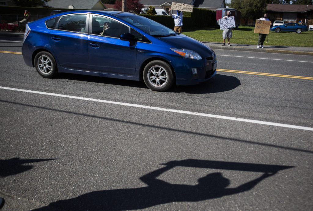 People wave and honk from the cars in support of protestors on Wednesday in Marysville. (Olivia Vanni / The Herald)
