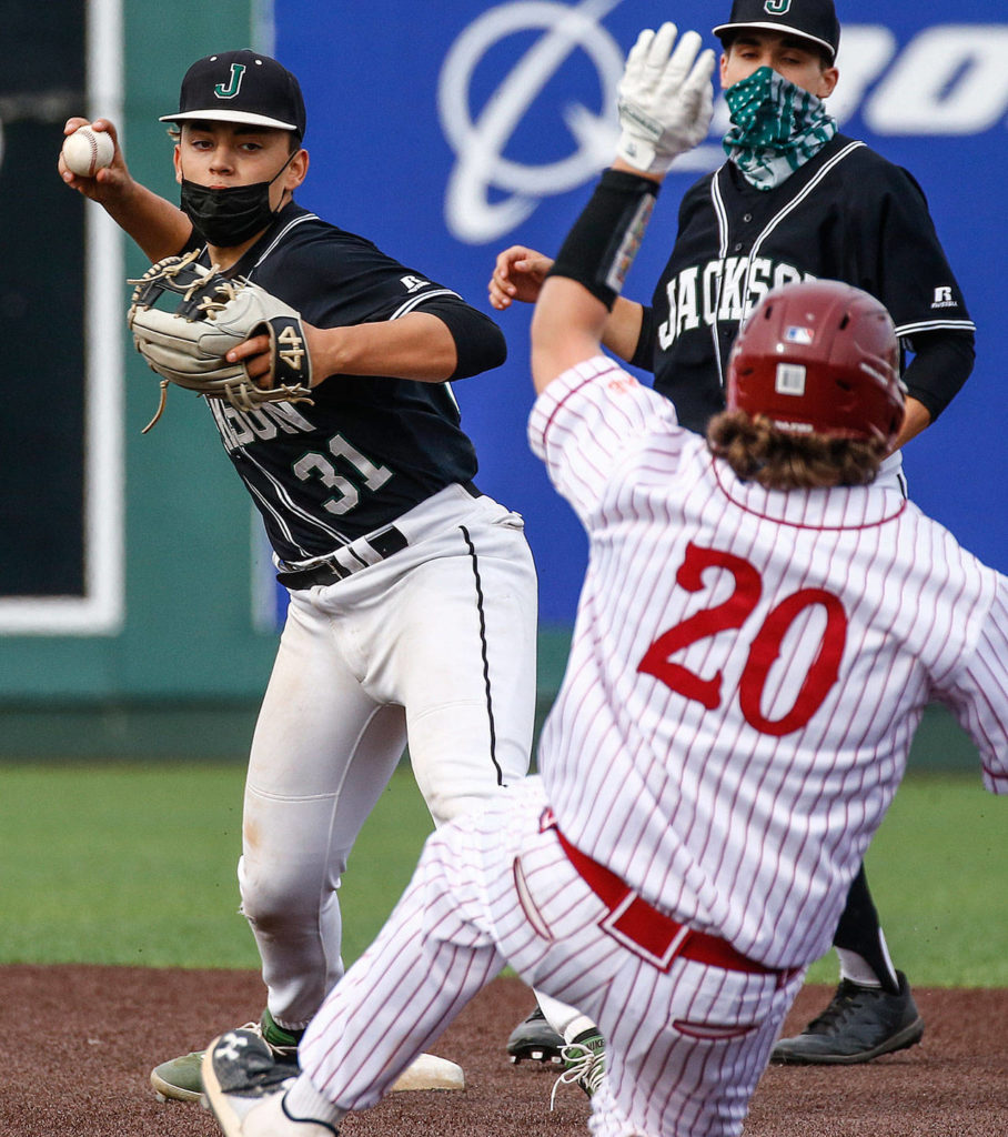 Jackson’s Ryan Contreras tags out Cascade’s Andre Livingston in the midst of a double play during a game April 23, 2021, at Everett Memorial Stadium. (Kevin Clark / The Herald)
