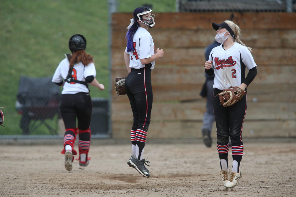 Marysville Pilchuck pitcher Kelsey Harris (left) and teammate Cassidy Phelps jump around before the start of an inning of a game against Jackson on April 28, 2021, in Mill Creek. Jackson beat Marysville Pilchuck 6-0. (Andy Bronson / The Herald)
