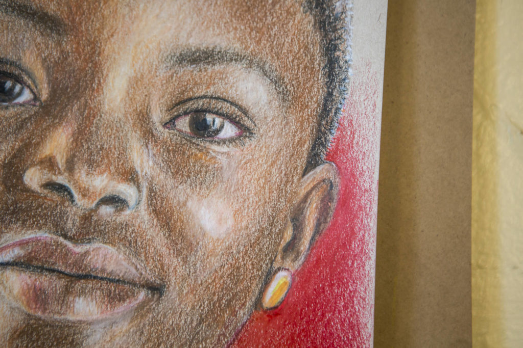 Cathy Tanasse uses a variety of colored pencils and colored backgrounds for her “Memory Project” portraits. (Olivia Vanni / The Herald)
