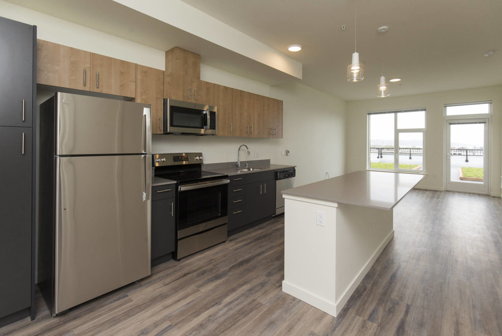 The windows in the kitchen and living room offer views of the water in the Waterfront Place Apartments in Everett. (Andy Bronson / The Herald)
