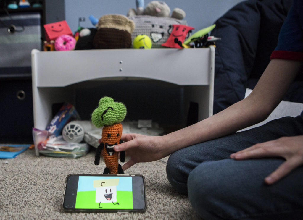 David Stowell’s animated YouTube series plays while he shows off some of his characters. (Olivia Vanni / The Herald)
