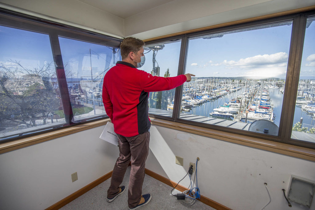 From the third floor crow’s nest of its new building in the Port of Everett’s South Marina, Everett Yacht Club Commodore John Seger points out what will be the club’s dock, Tuesday in Everett. (Andy Bronson / The Herald)
