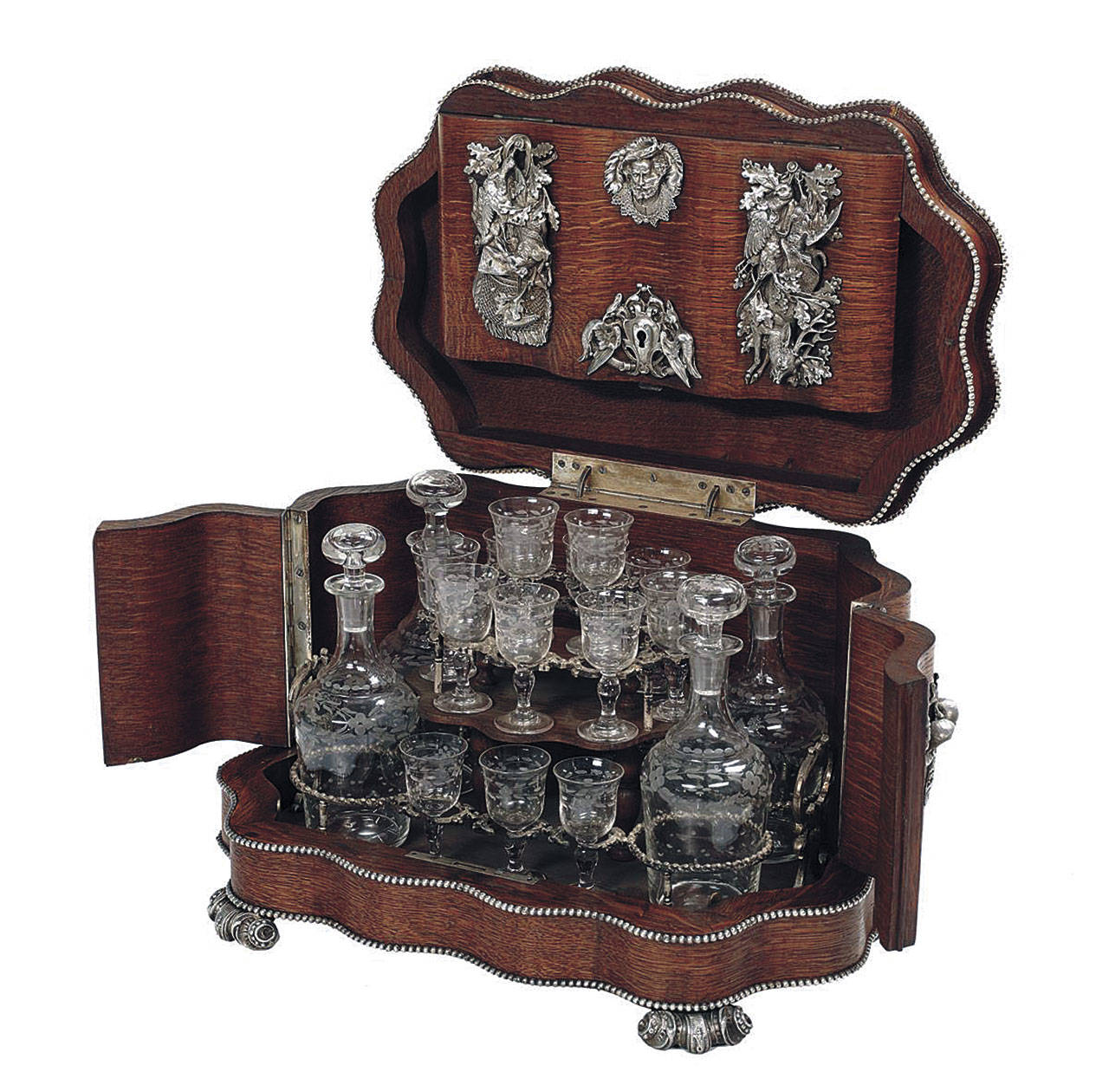This oak 19th-century “cave a liqueur” holds four decanters and 16 liqueur glasses. It is decorated with silvered mounts of hunting dogs. The 11-inch-high box sold at New Orleans Auction Galleries for $4,250. (Cowles Syndicate Inc.)