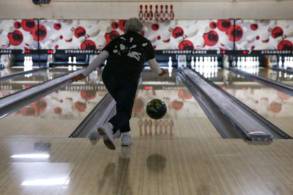 Mae Tomita picks up a spare in the first frame Wednesday afternoon at Strawberry Lanes in Marysville, where family and friends celebrated her 100th birthday. (Kevin Clark / The Herald)
