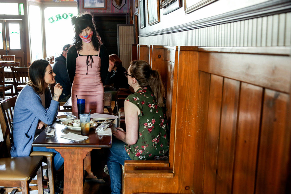 Breanna Schalamon takes an order from Danielle LaRosee (left) and Jacqueline Burns Tuesday afternoon at Oxford Saloon in Snohomish. (Kevin Clark / The Herald)
