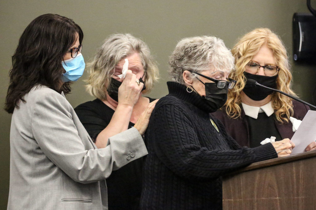 Daughters Erin Van Ry (left) and Jennifer Parks listen as their mother, Kathy Parks, addresses the court with Nanci Bidondo (far right) Thursday, when Elmer Nash was sentenced for the 1987 arson that killed firefighter Gary Parks. (Kevin Clark / The Herald)
