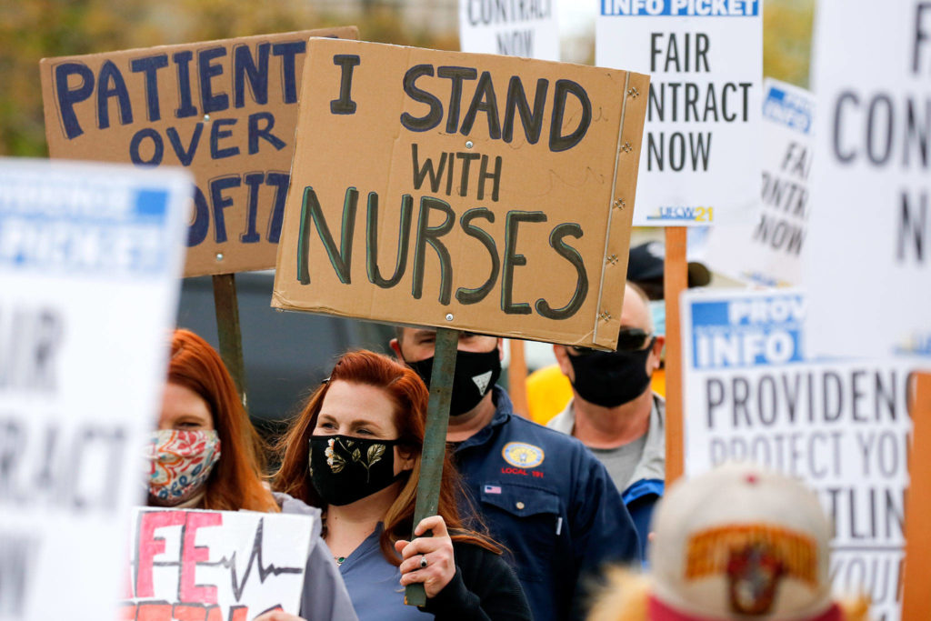 Picketers march Wednesday afternoon across from Providence Medical Center in Everett. (Kevin Clark / The Herald)
