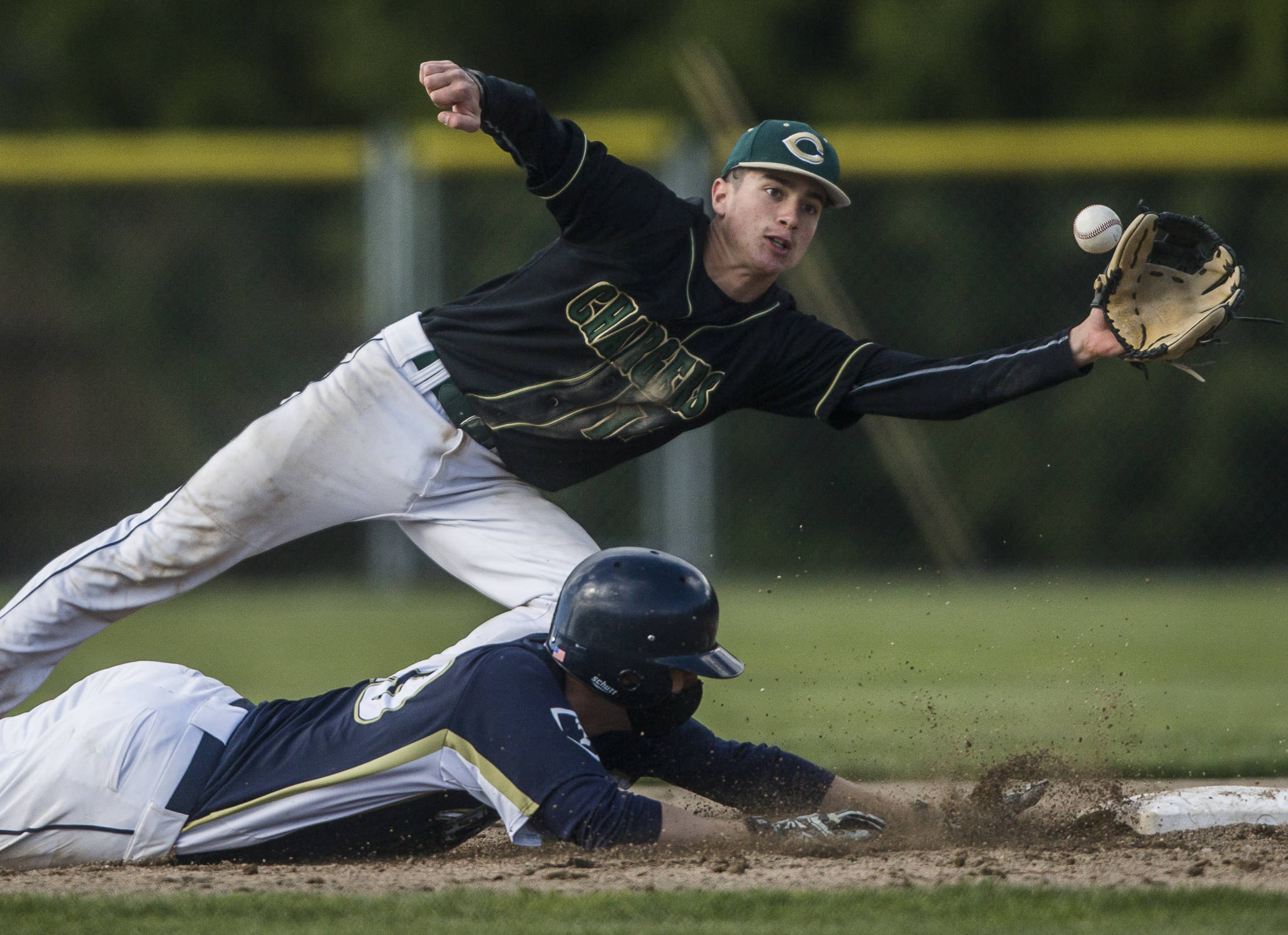 Marysville Getchell’s Ethan Jury top reaches out for the ball as Arlington’s Nick Salstrom dives back to second base during a game on May 7, 2021, in Arlington. (Olivia Vanni / The Herald)