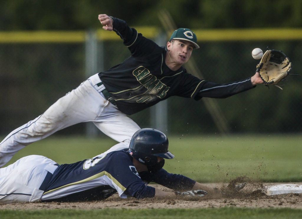 Marysville Getchell’s Ethan Jury top reaches out for the ball as Arlington’s Nick Salstrom dives back to second base during a game on May 7, 2021, in Arlington. (Olivia Vanni / The Herald)
