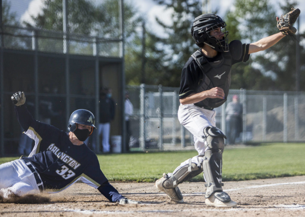 Arlington’s Nick Salstrom slides into home to score during a game against Marysville Getchell on May 7, 2021, in Arlington. (Olivia Vanni / The Herald)

