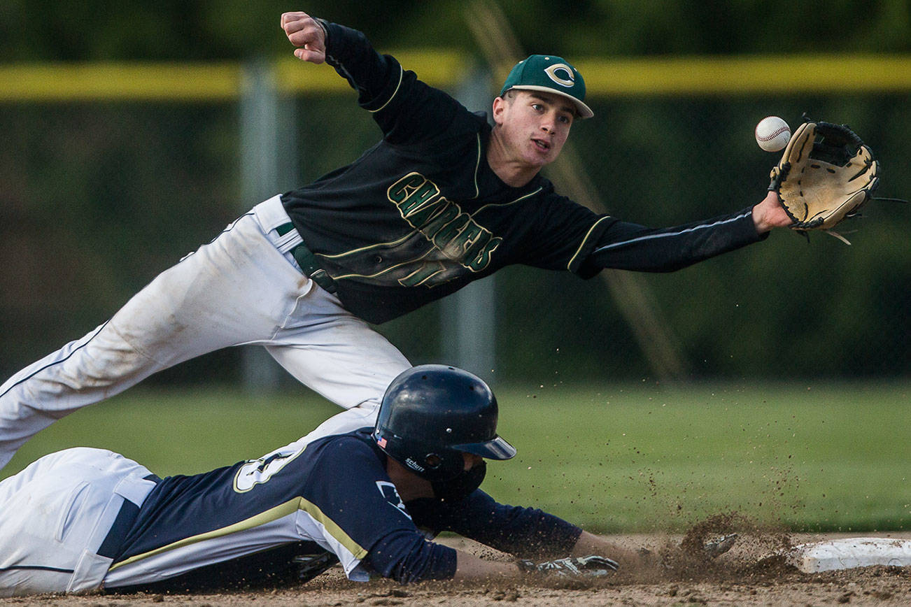 Marysville Getchell's Ethan Jury reaches out for the ball as Arlington's Nick Salstrom dives back to second base during the game on Friday, May 7, 2021 in Arlington, Wash. (Olivia Vanni / The Herald)