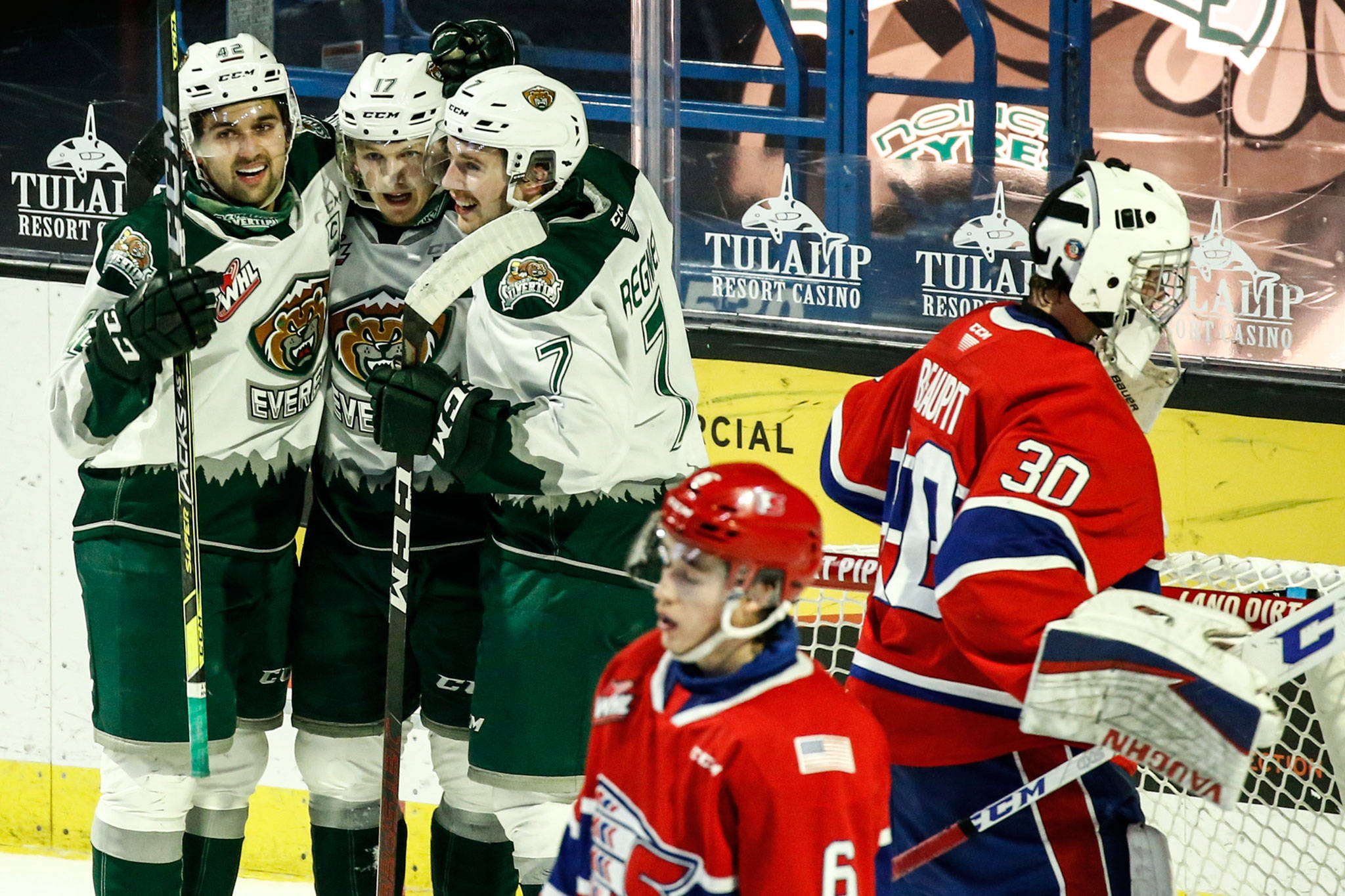 The Silvertips’ Cole Fonstad (left-right), Jackson Berezowski and Ethan Regnier celebrate Berezowski’s goal in the second period as the Chiefs’ Mac Gross (6) and Mason Beaupit (30) look on during a game on May 7, 2021, at Angel of the Winds Arena in Everett. (Kevin Clark / The Herald)
