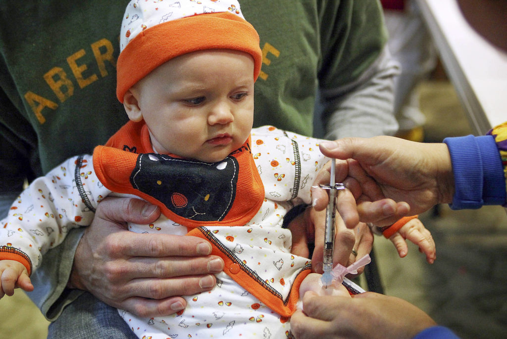 Claire Swander, 6 months old, gets an H1N1 vaccine from nurse Soon Ku at Providence Physician Group in Mill Creek on Oct. 31, 2009. The site had lines with a three-hour wait for portions of the morning. (Heidi Hoffman / Herald file)
