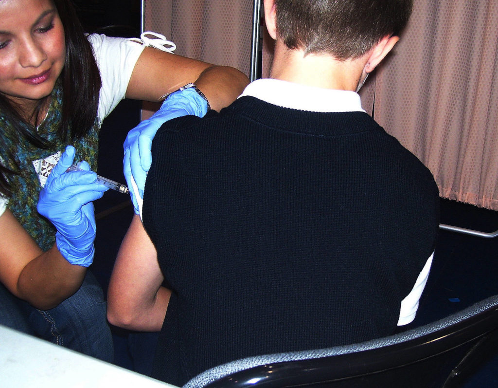 Cinda Schmidt administers the H1N1 vaccine to John Muhlstein, 11, at a gym on the Tulalip reservation on Nov. 2, 2009. (Julie Muhlstein / The Herald)
