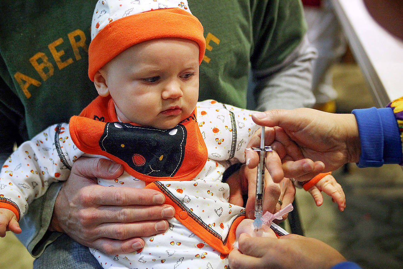 Claire Swander, 6 months old, gets an H1N1 vaccine from nurse Soon Ku at Providence Physician Group in Mill Creek on Oct. 31, 2009. The site had lines with a three-hour wait for portions of the morning. (Heidi Hoffman / Herald file)