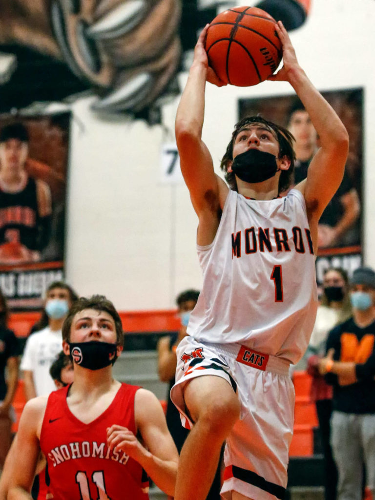 Monore’s Steve Kuhnle attempts a layup with Snohomish’s Wes Ostlund looking on during a game on May 11, 2021, at Monroe High School. The Bearcats won 36-35. (Kevin Clark / The Herald)
