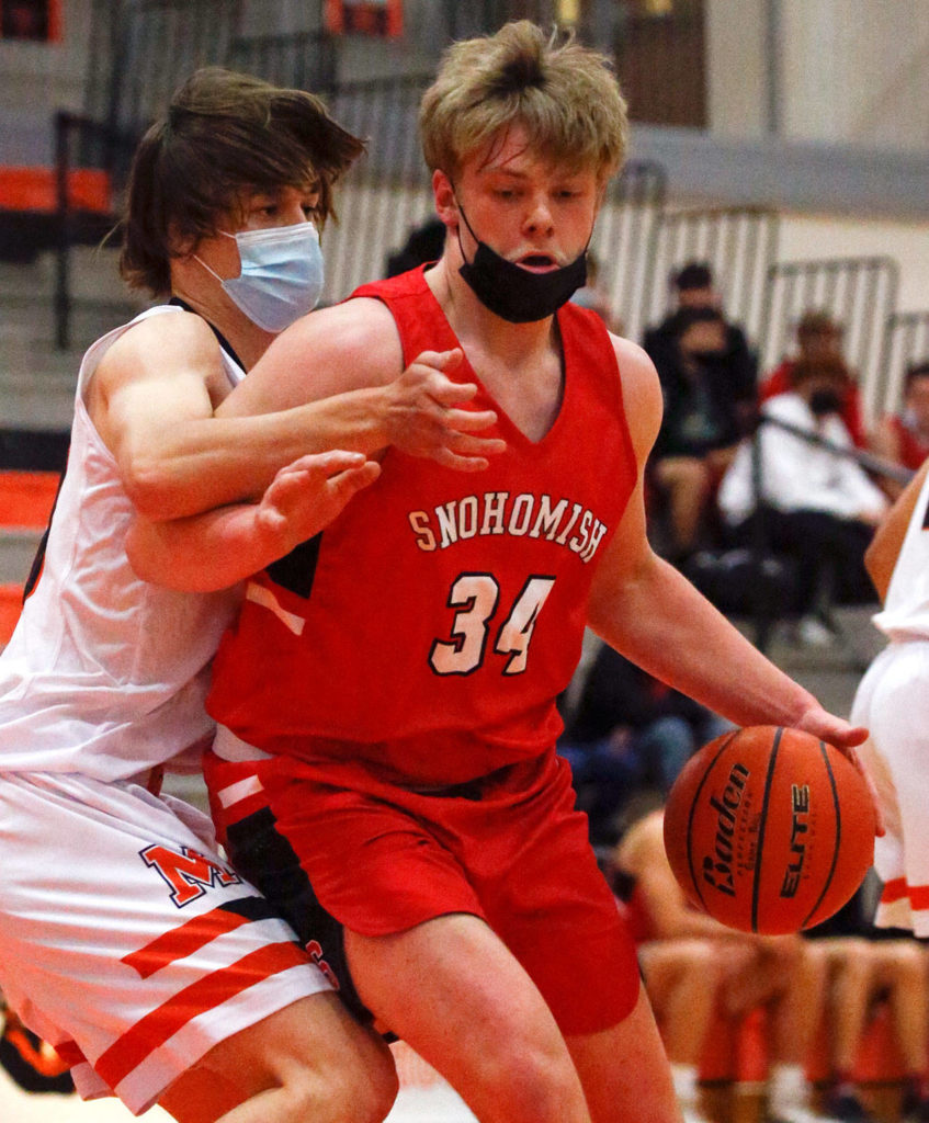 Snohomish’s Grady Kentch controls the ball Monroe’s Ryan Lynch defending during a game on May 11, 2021, at Monroe High School. The Bearcats won 36-35. (Kevin Clark / The Herald)
