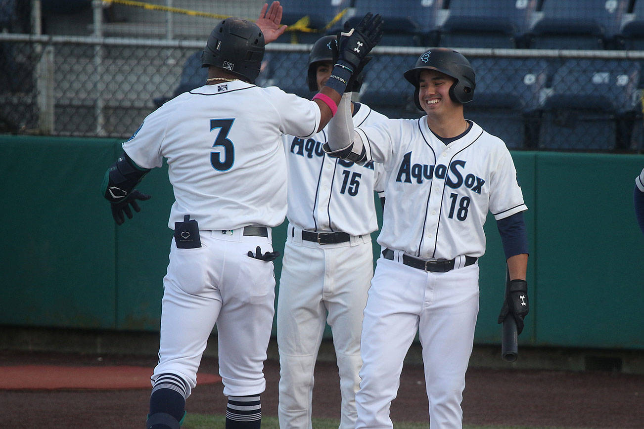 Aquasox's Julio Rodriguez gets a high five from Austin Shelton as he crosses home plate after hitting a two-run homer. The Everett Aquasox beat the Tri-City Dust Devils in a home opening game at Funko Field on Tuesday, May 11, 2021 in Everett, Washington.  (Andy Bronson / The Herald)