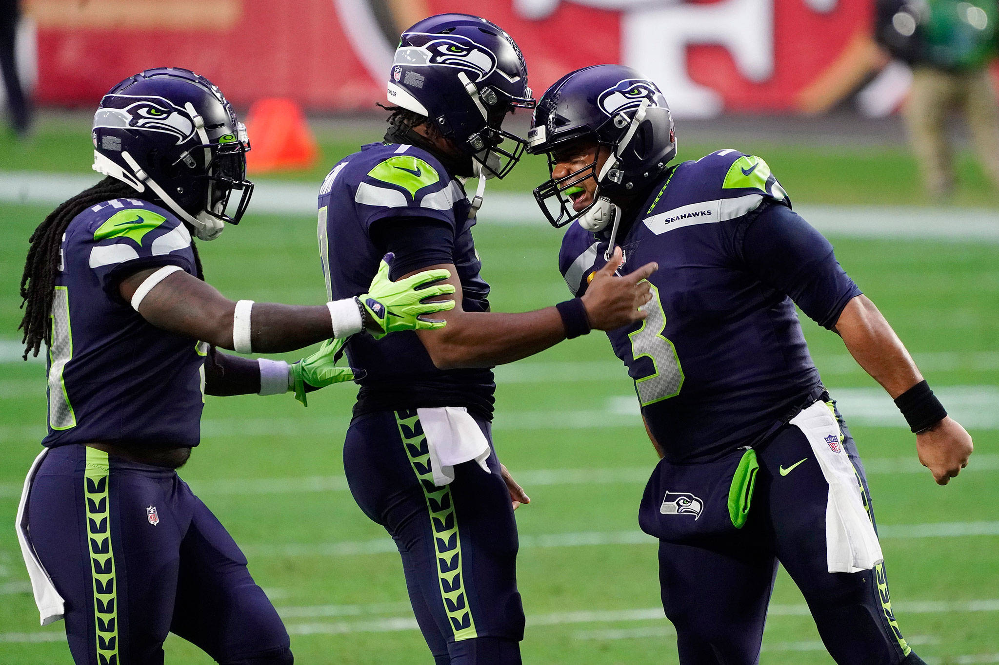 Seahawks quarterback Russell Wilson (right) celebrates after a touchdown against the 49ers with quarterback Geno Smith (center) and running back Alex Collins during the second half of a game Jan. 3, 2021, in Glendale, Ariz. (AP Photo/Rick Scuteri)