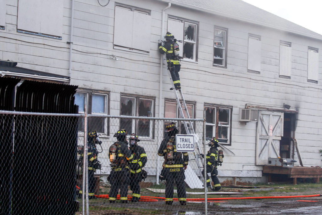 Firefighter douse the flames at the vacant NOAA Research Station Friday evening in Mukilteo. (Kevin Clark / The Herald)

