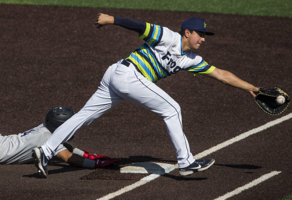 AquaSox’s Austin Shenton reaches for an other thrown ball to first base during the game against the Dust Devils on Sunday, May 16, 2021 in Everett, Wash.

