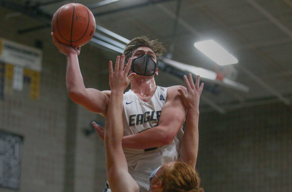 Arlington’s Jaden Roskelley shoots over Lakewood’s Andrew Molloy for a basket during a game on May 19, 2021, in Arlington. (Andy Bronson / The Herald)
