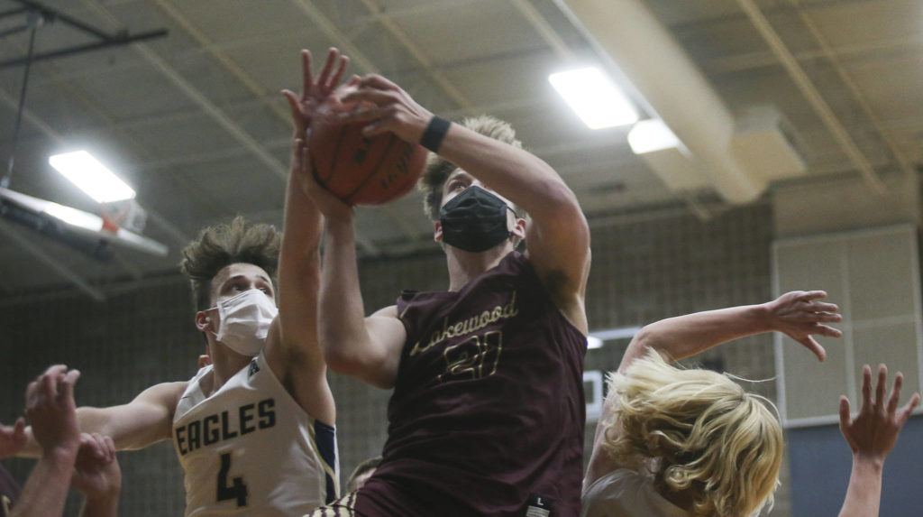 Lakewood’s Blake Conyers tries for a basket under heavy pressure during a game against Arlington on May 19, 2021, in Arlington. (Andy Bronson / The Herald)
