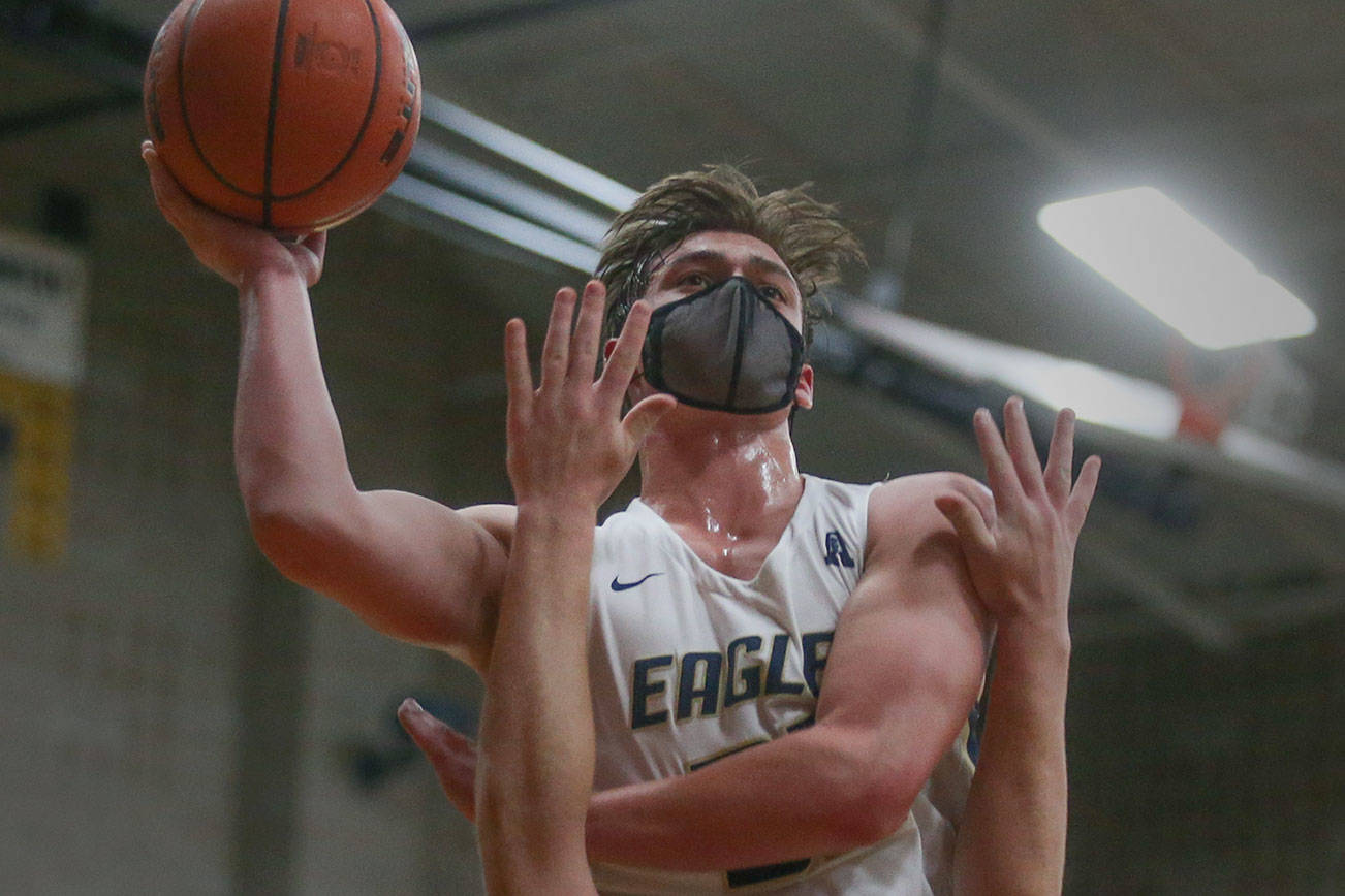 Arlington's Jaden Roskelley goes over Lakewood's Andrew Molloy for the basket as Arlington took on Lakewood in a non-conference boys' basketball game on Wednesday, May 19, 2021 in Arlington, Washington.  (Andy Bronson / The Herald)