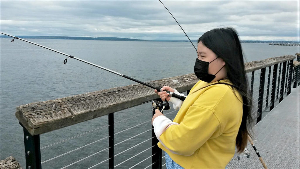 Allison Kim, 10, awaits a bite as she fishes at the new fishing pier Sunday near the Mukilteo ferry terminal. (Julie Muhlstein / The Herald)
