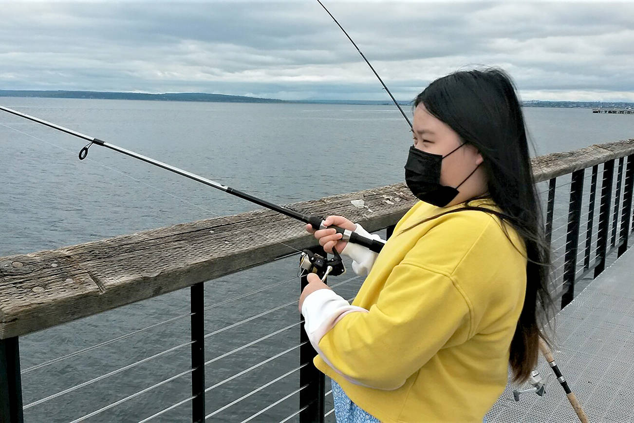 Allison Kim, 10, awaits a bite as she fishes at the new fishing pier Sunday near the Mukilteo ferry terminal. (Julie Muhlstein / The Herald)
